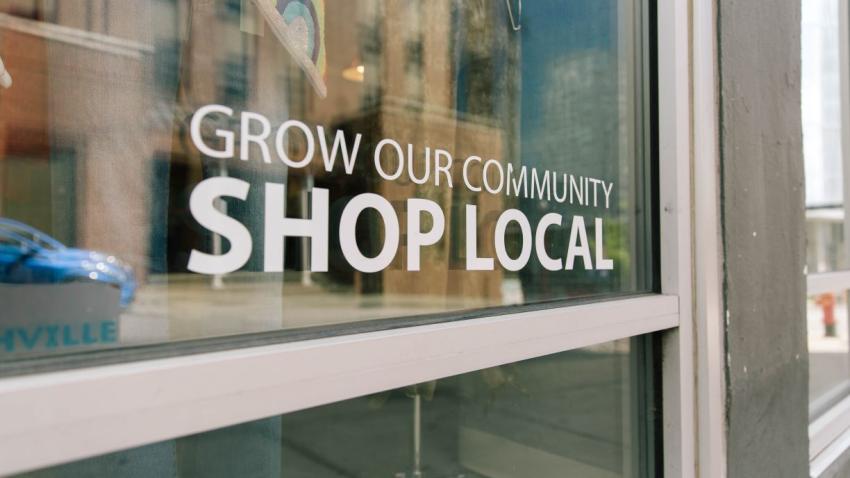 a storefront window that says shop local
