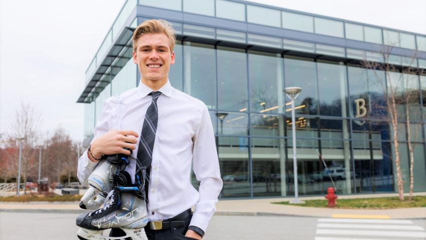 Lucas in front of the Bentley Arena holding skates