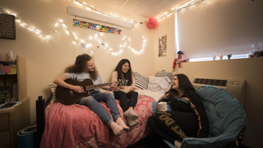 three students in dorm room
