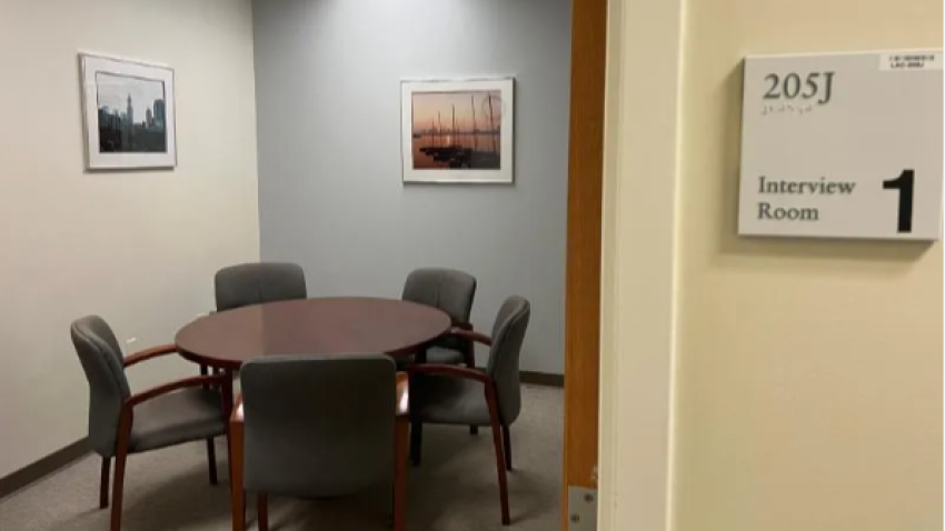 Photo of an empty interview room containing tables and chairs