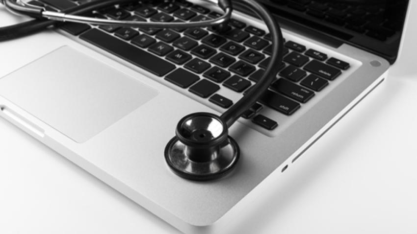 A stethoscope on top of an open laptop.