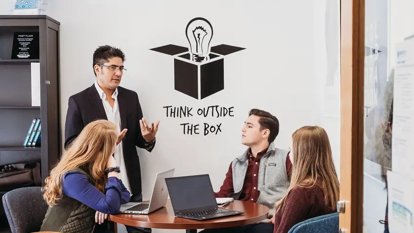 Professor Christian Rubio speaks with three students about course content