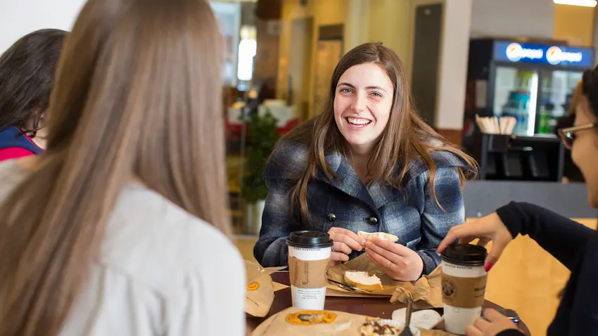 happy student eating with her friends