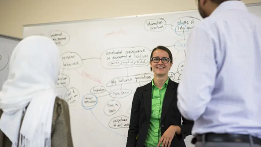 Taking Charge participant discusses strategy with another student and professor