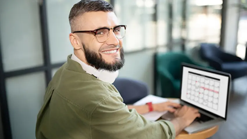 Man smiling and working on laptop