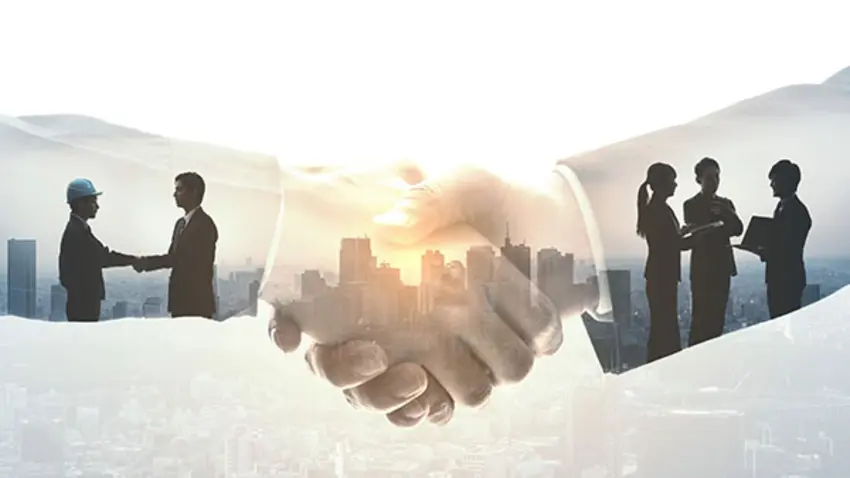 Hands shaking with people networking in the background 