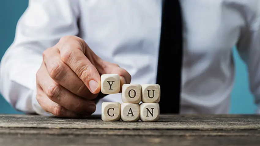 Man with blocks spelling "You Can"