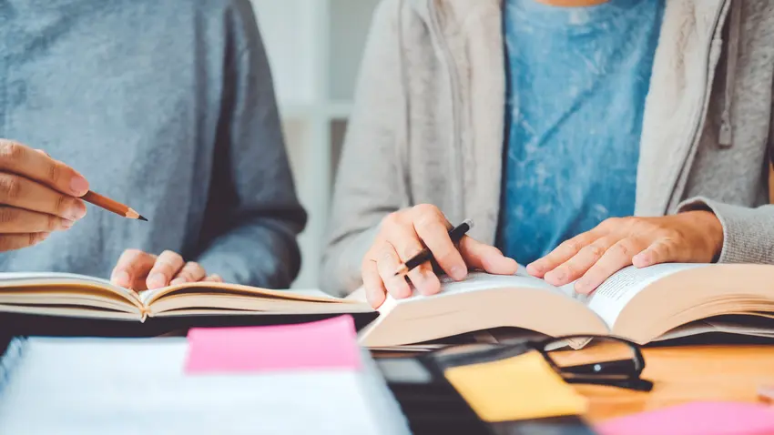 Students reading over books together