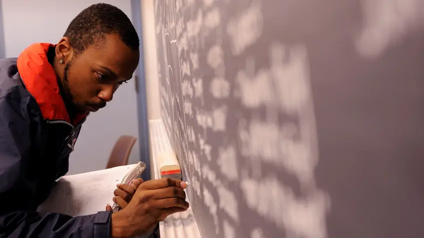 Student doing math on chalkboard