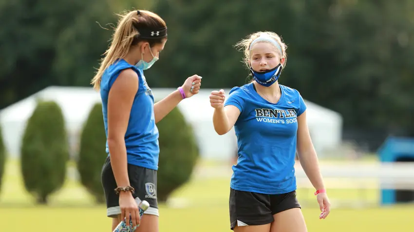 Women soccer players fist bumping