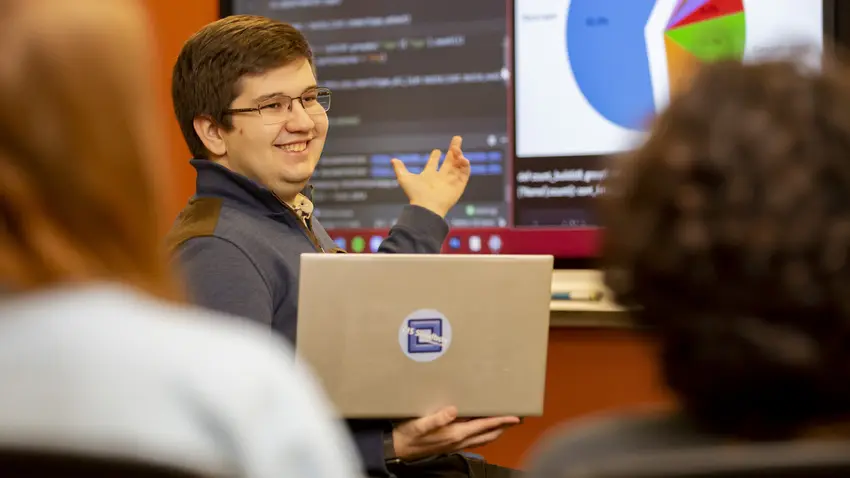 Cem Özsümer '23 tutoring students in the CIS Sandbox with a computer