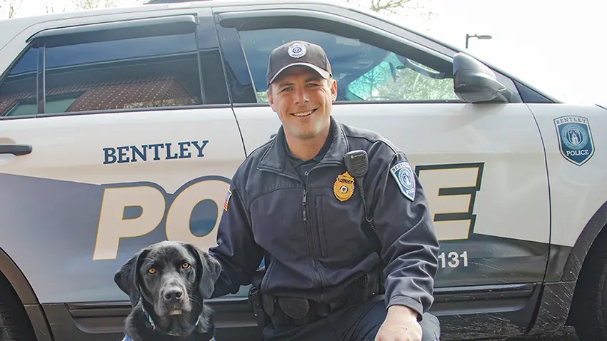 Sergeant Bartkus and Blue the Comfort Dog pose in front of their car