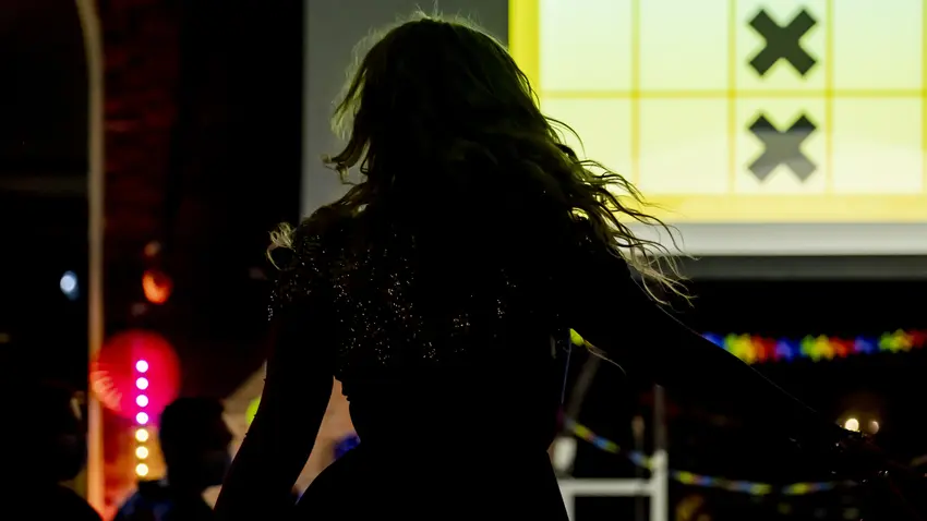 Shadow of drag queen performer with lights in the background