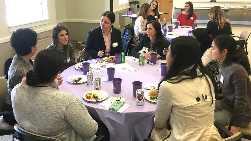 Photo of women sitting around table conversing