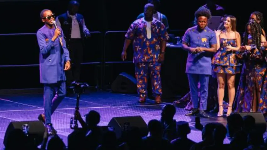 Kweku Ashiagbor with microphone on stage with crowd