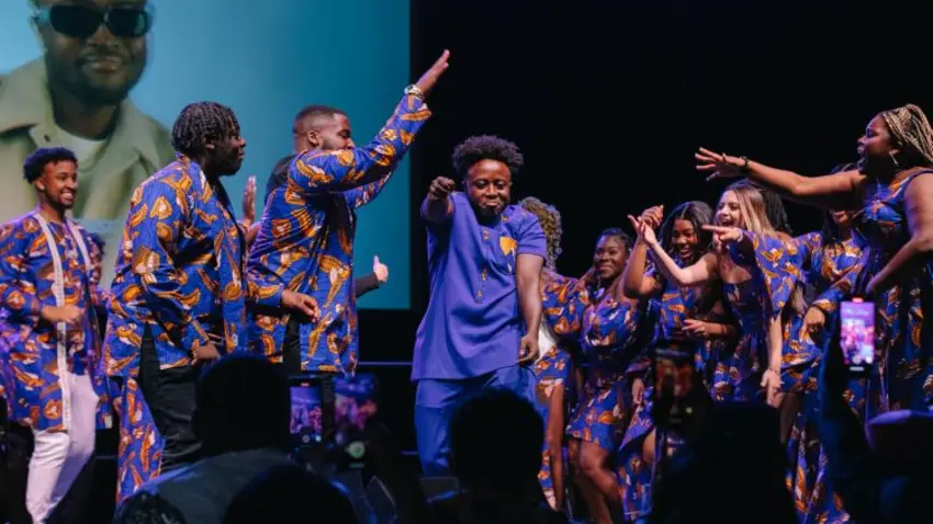 Augustine Peprah dancing on stage with large group