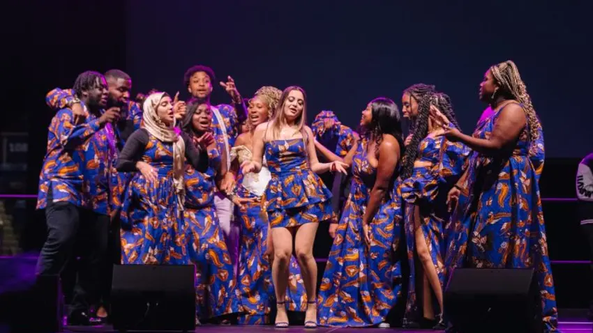 Students wearing African attire dancing on stage