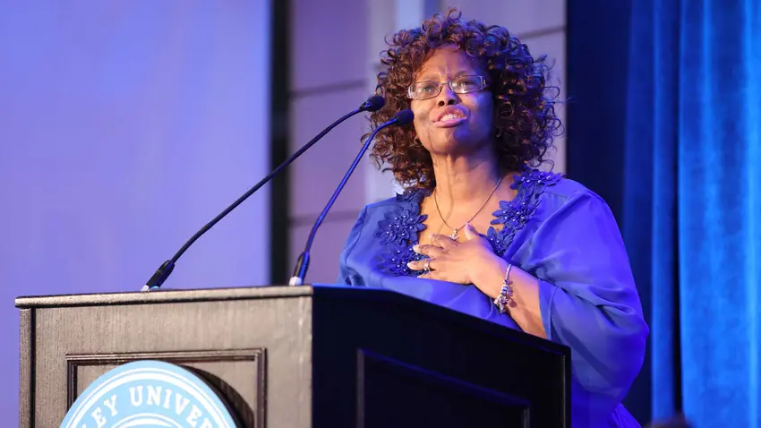 Claudette speaking on stage