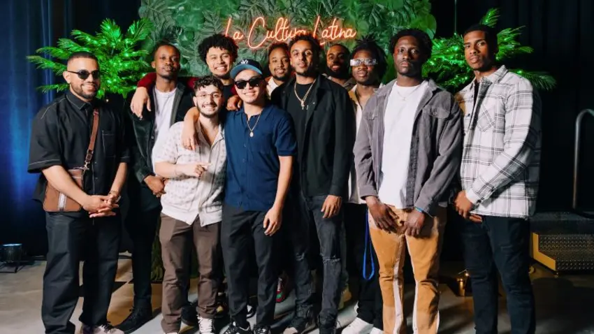 People standing in front of green floral wall