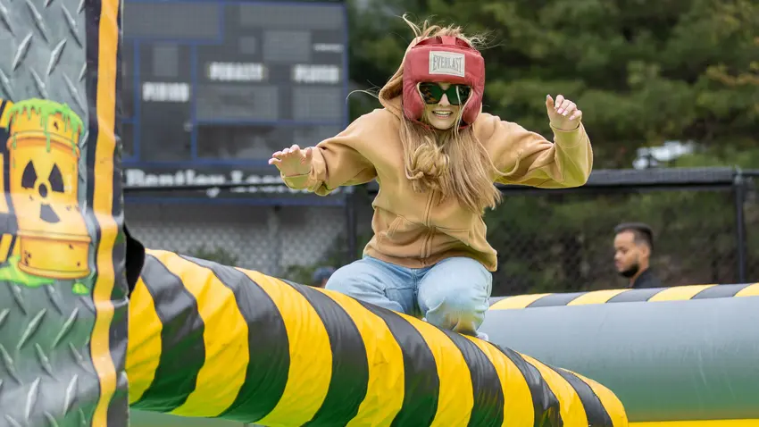 Students jumping over a post in inflatable wipeout game
