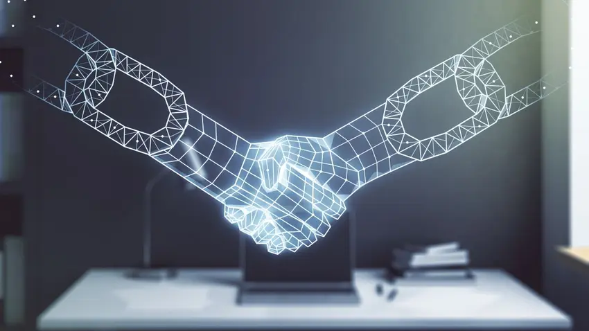 Blockchain handshake with laptop and desk in background