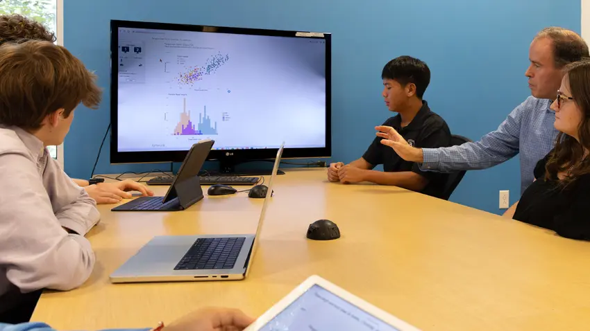 group of precollege students look at screen with teacher hero