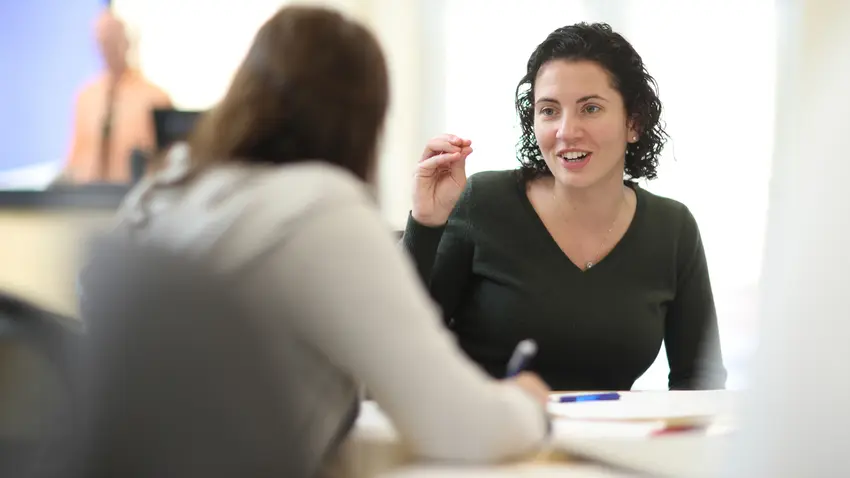 Two women talking in a classroom