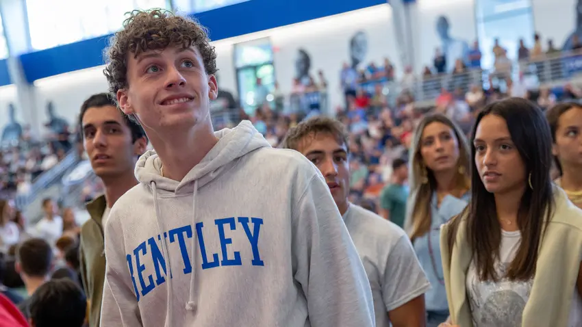 a member of the class of 2027 wearing a Bentley University sweatshirt
