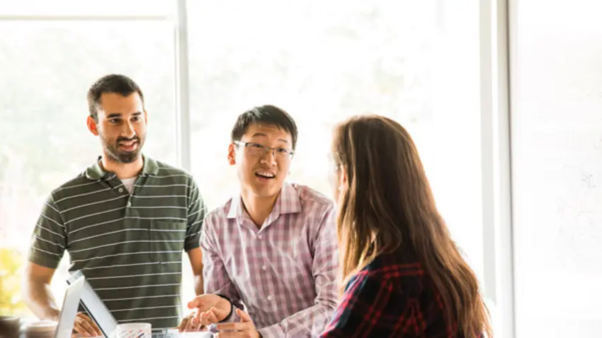 three people talk together in office environment 