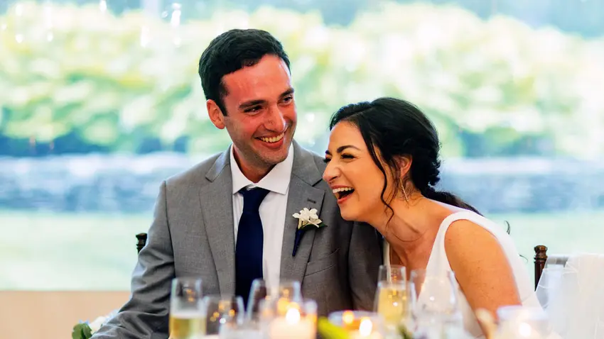 a couple sitting at a table during a wedding