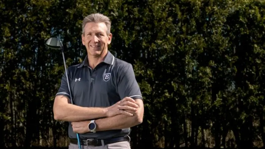 David Scholnick in Bentley t-shirt holds a golf club.