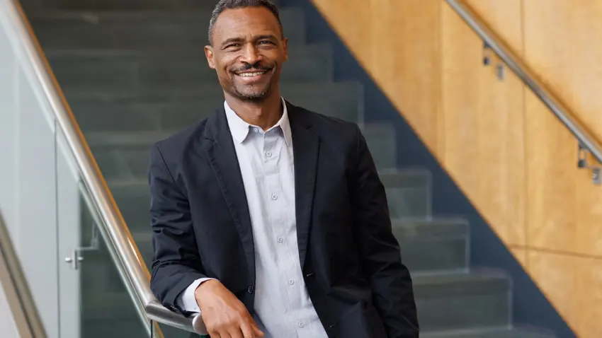 João Resende-Santos, an associate professor of international studies, stands at the foot of a staircase in Smith Hall, his right arm resting atop the banister. 