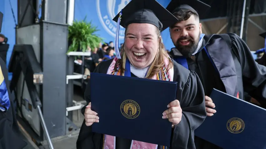 Bentley University graduates pose during commencement ceremony