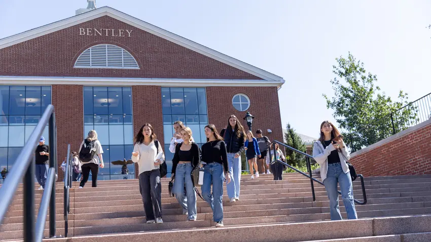 Students walking down stairs in front of Bentley University library