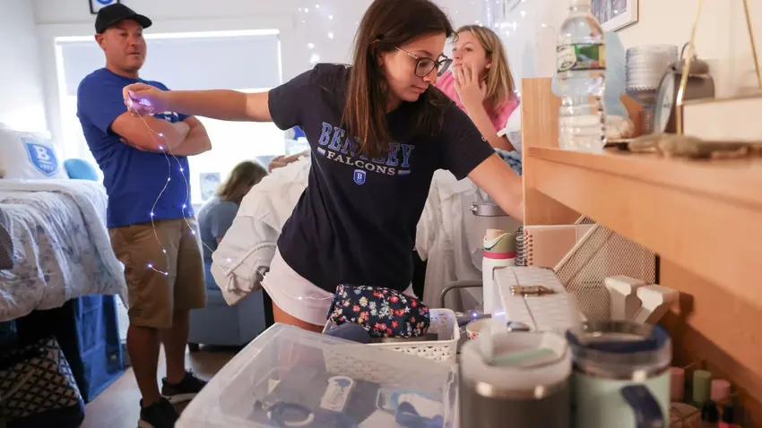 Bentley Class of 2028 student hangs lights in dorm room