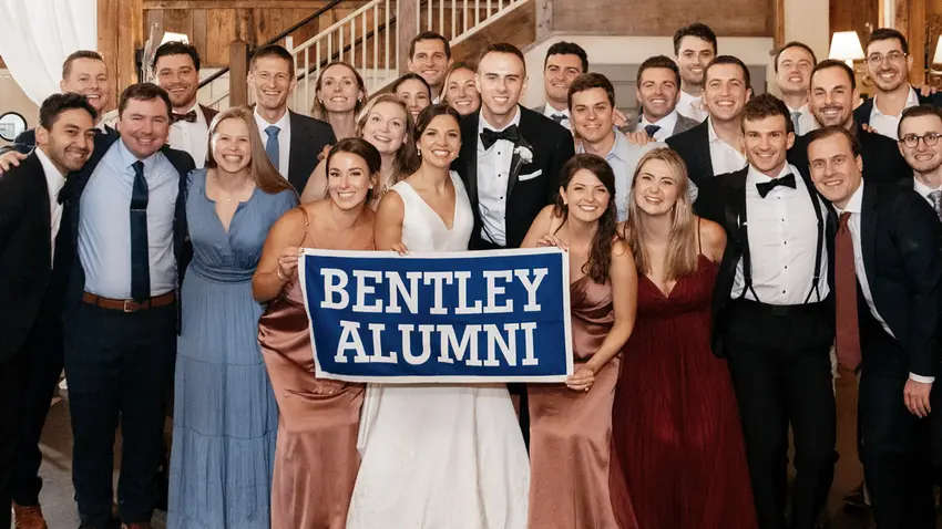 alumni pose at a wedding