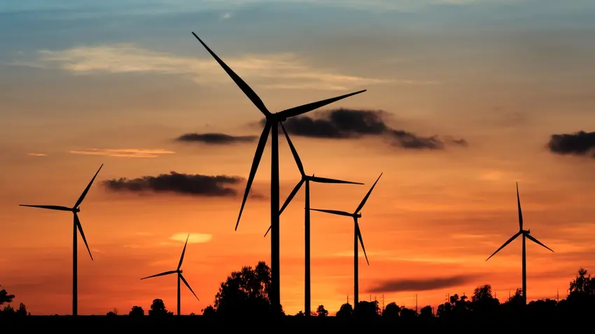 Wind farm against orange sky