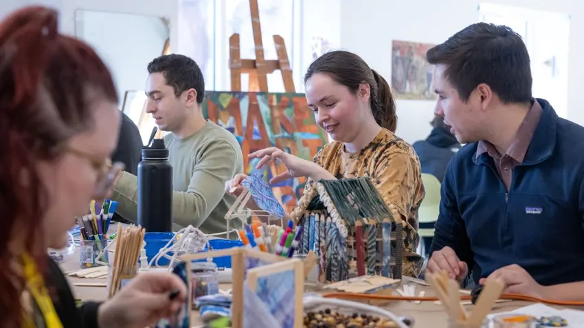 Participants at Ifé Franklin's slave cabin art workshop at the Bentley MLK social justice program  using craft sticks, fabric, shells, raffia, beads and buttons.