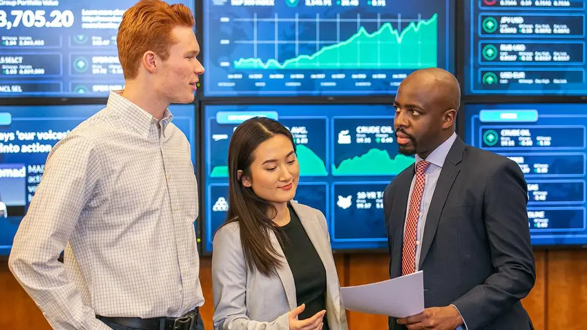 Students and professor in Bentley University's trading room