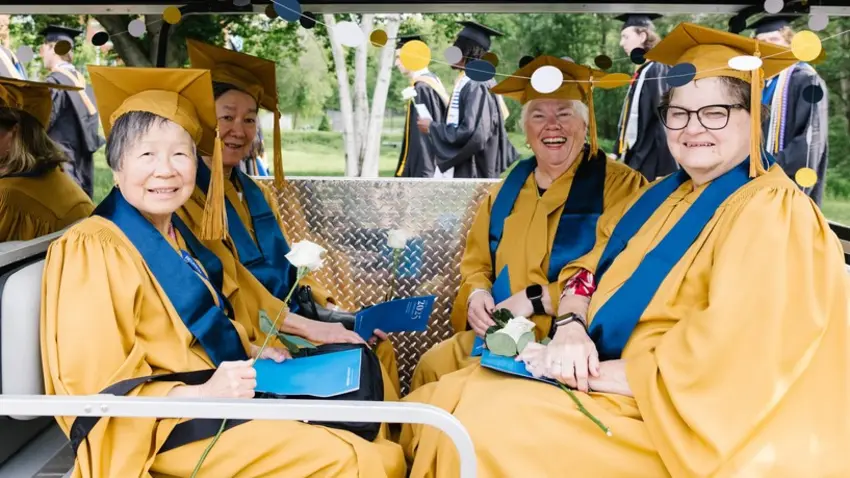 Reunion attendees in regalia on a golf cart