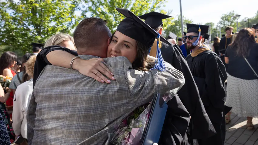Woman hugs father after graduation