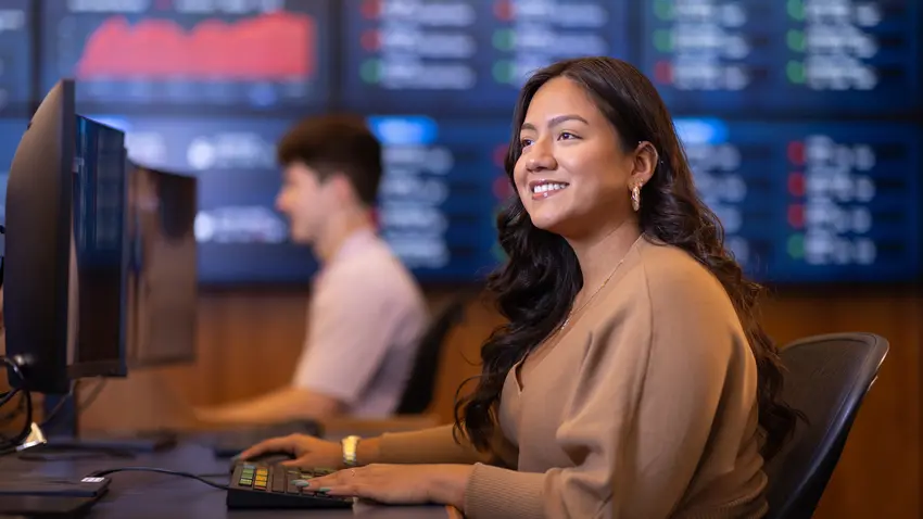 This image is a woman sitting at a terminal in Bentley's Trading Room.