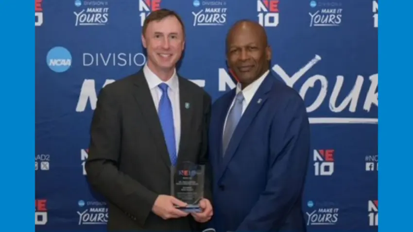 Accounting professor Eric Gaynor holds his NE10 award while posing with Athletics Director Vaughan Williams