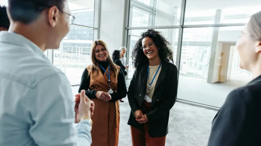 Two people, representing networking buddies, engage with another person at an event