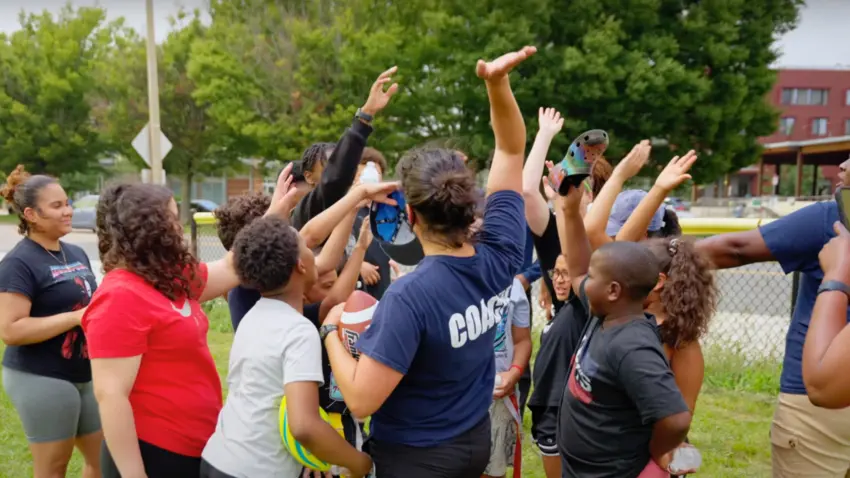 Doc Wayne coaches connect with youth with a group high-five while running a sport-based group therapy program.