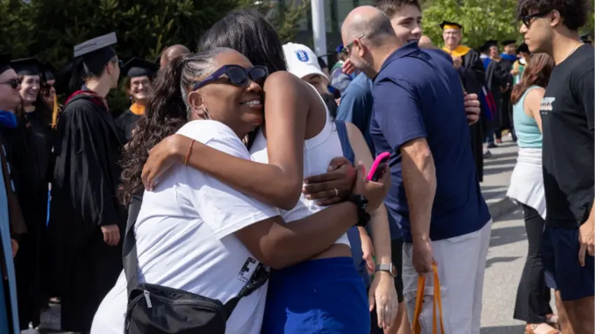 A family embraces their student during Bentley Class of 2029 move-in day