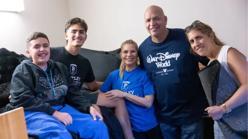 Bentley family poses in dorm room with student during Class of 2029 move-in day