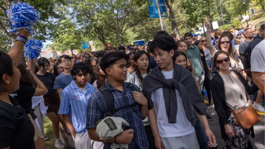 People converse with smiles during a procession for Bentley Class of 2029 during move-in day