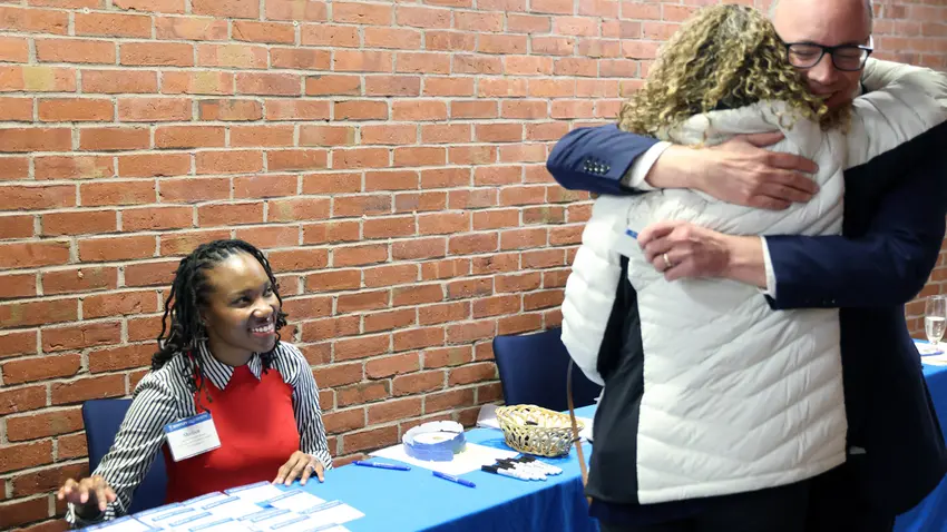 a woman handing out nametags