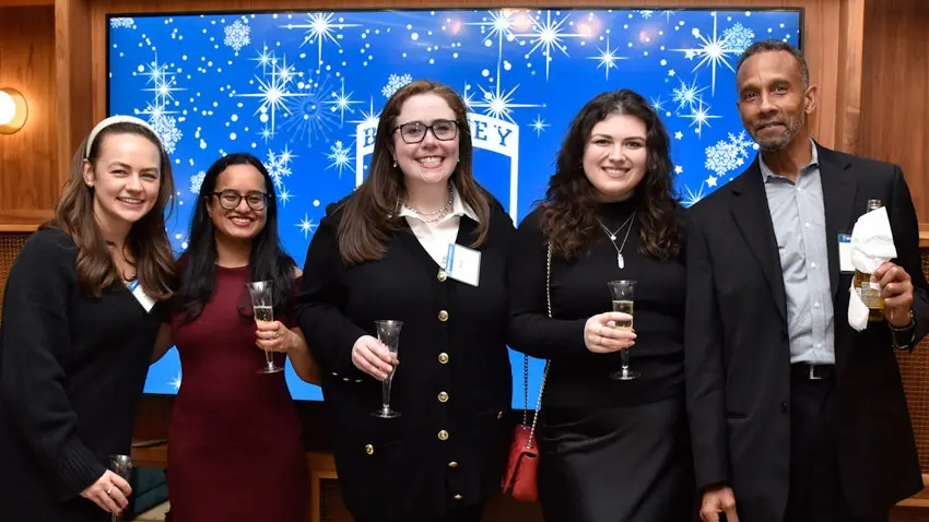 alumni smiling at a holiday party